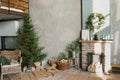 Interior of a country house with a fireplace, a Christmas tree, a wicker chair and decor for the new Year