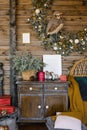 Interior of a country house room with a Christmas wreath, antique chest of drawers and decor for Christmas and New Year Royalty Free Stock Photo