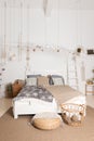 Interior of cozy and bright bedroom. Bed with white, beige and grey bedclothes