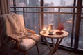 Interior with cozy chair and table with coffee and sweets against backdrop of winter city outside window