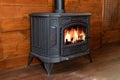 Interior cozy living room with black modern Cast iron wood stove at home. Wood burning stove, traditional heating system. Royalty Free Stock Photo