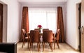 Interior of a cozy sitting room, a flowering plant on a table with chairs around it