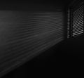 interior of dark room. shadow of the rays falling on the wall through the louvers. Light from the lamp and shadow on room wall Royalty Free Stock Photo