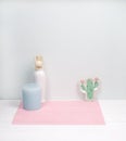 Interior decoration of a home, candle, flower, support cactus and white vase on pink napkin, white wood background. Modern interi Royalty Free Stock Photo