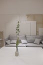 Interior decoration, with soft sofa and white table. Branches in the vase on the table. Cozy place for rest Royalty Free Stock Photo