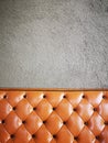 Vintage orange or brick colour leather sofa with grey concrete wall background. Royalty Free Stock Photo