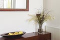 Interior decorator items flowers buffet and mirror in luxury home