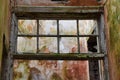 Interior of derelict building with broken window, peeling paint and mould on walls Royalty Free Stock Photo