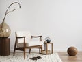 Interior design of aesthetic and minimalist living room with boucle armchair, wooden coffee table, pedant lamp, beautiful leafs in