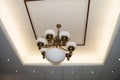 Interior design ceiling with led spot light fixtures and vintage bronze retro style lamp, white luxury designer ceiling