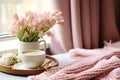 interior design, Cozy Easter, spring still life scene. Cup of coffee, opened notebook, pink knitted plaid on windowsill.