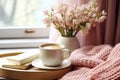 interior design, Cozy Easter, spring still life scene. Cup of coffee, opened notebook, pink knitted plaid on windowsill.