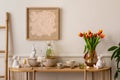 Interior design of easter living room interior with mock up poster frame, glass vase with tulips, wooden sideboard, easter bunny