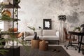 Interior design of indiustral living room interior with mock up poster frame, gray sofa, round wooden coffee table, brown leather Royalty Free Stock Photo