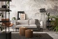 Interior design of indiustral living room interior with mock up poster frame, gray sofa, round wooden coffee table, brown leather Royalty Free Stock Photo