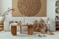 Interior design of japandi living room with mock up poster frame, modular beige sofa, vase with rowan, round wooden coffee table, Royalty Free Stock Photo