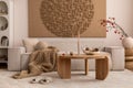 Interior design of japandi living room with mock up poster frame, modular beige sofa, vase with rowan, round wooden coffee table, Royalty Free Stock Photo