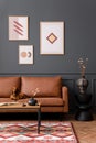 Interior design of living room interior with mock up poster frame, brown sofa, patterned rug, wooden coffee table, vase with dried Royalty Free Stock Photo