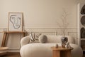 Interior design of living room interior with mock up poster frame, white sofa, wooden coffee table, patterned round pillows, vase