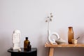 Interior design of living room interior with wooden bench, black round coffee table, glass vase, bright sculpture, vase with dried Royalty Free Stock Photo