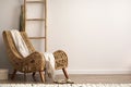 Interior design of meditation living room interior with copy space, armchair, beige carpet, plaid and personal accessories. Home