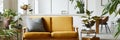 Interior design of scandinavian open space with yellow velvet sofa, plants, furniture, book, wooden cube and personal accessories.