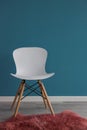 Interior design scene with a modern white chair on blue wall Royalty Free Stock Photo