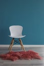 Interior design scene with a modern white chair on blue wall Royalty Free Stock Photo