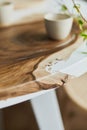 Interior design of stylish dining room interior with family wooden and epoxy table, rattan chairs, flowers in vase and teapot. Royalty Free Stock Photo