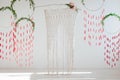 Interior design with weaving and flowers. Spring dream catchers with green leaves and red brushes. Wicker arch on a