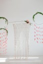 Interior design with weaving and flowers. Spring dream catchers with green leaves and red brushes. Wicker arch on a