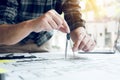 Interior designer or architect reviewing blueprints and holding pencil drawing on desk at home office Royalty Free Stock Photo