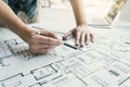 Interior designer or architect reviewing blueprints and holding pencil drawing on desk at home office Royalty Free Stock Photo