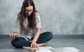 The interior designer plans the future interior sitting on the floor in an empty apartment. Royalty Free Stock Photo