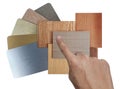 interior designer's hand choosing combination of various texture and colors of wooden veneer and stainless metallic samples