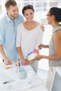Interior designer showing colour wheel to happy clients Royalty Free Stock Photo
