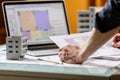 Interior designer working with an apartment plans in a studio, with blueprints and laptop on a table