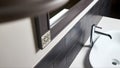 Interior detail of bathroom with washbasin and faucet. Bathroom interior sink with gray tiled wall and mirror modern