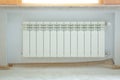 Just installed a new steel heating radiator. Full view of a white radiator against a cream wall . Interior detail. White Royalty Free Stock Photo