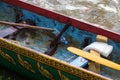 Interior detail of wooden racing boat after a traditional racing event in Cambodia, revealing paddles, painted detail, and water b