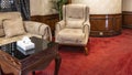 Interior details. On the red carpet there is a soft beige armchair,