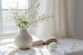 Interior details. Stylish ivory Scandinavian minimalistic interior with white flowers in vase on table near window with Royalty Free Stock Photo