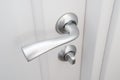 Interior doors fittings. Matte metal door handle with lock on white wooden Interior door Royalty Free Stock Photo