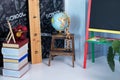 Interior of elementary school. Chalkboard, Books, globe and stationery on classroom. Teachers Day concept. Back to school. Empty c