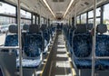 Interior of an empty city bus featuring two rows of upholstered seats with blue, geometric-patterned Royalty Free Stock Photo
