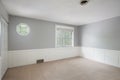 Interior of an empty renovated gray and white room with two windows