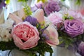 Interior floral arrangement of pink and lilac peonies and roses with green leaves. Beautiful floral background