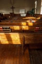 Window light falls on church seating. Royalty Free Stock Photo