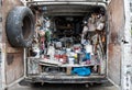 Interior of a home decorator`s van photographed from the rear, full of old tins of paint accessories, brushes and other supplies