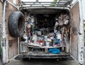 Interior of a home decorator`s van photographed from the rear, full of old tins of paint accessories, brushes and other supplies